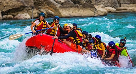 Team paddling together down rapids