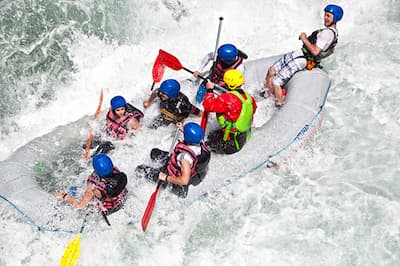 Team paddling together down rapids